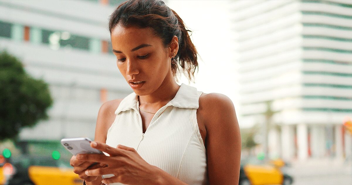 Woman checking her phone while thinking about her pregnancy and ultrasound.